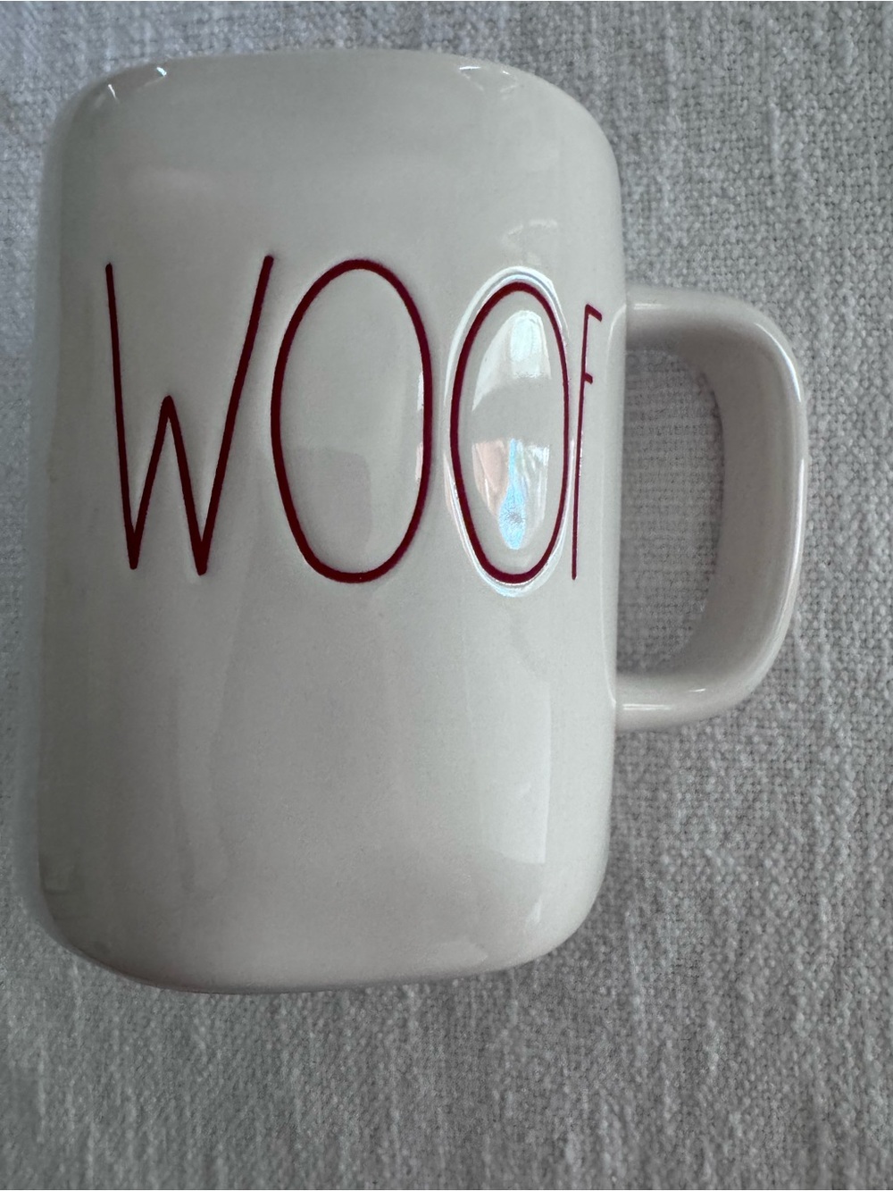 Rae Dunn WOOF ceramic mug by Magenta featuring red lettering.